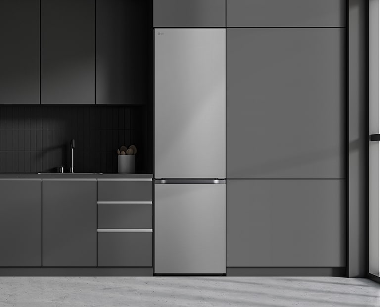 Cocina moderna con armarios grises, nevera LG plateada a la derecha y ventana alta a la derecha.