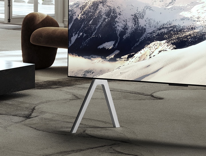 Salón espacioso con vistas de una ciudad. Hay un televisor LG OLED TV montado en la pared con una LG Soundbar. Desde un lado, el diseño en pared del televisor y los biseles ultradelgados permiten que se integre bien con la pared y el espacio. La Zero Connect Box está visible, pero oculta.