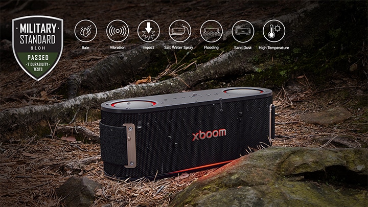 xboom Bounce está colocado en suelo cubierto de hojas húmedas, entre una raíz de árbol y una piedra. En la parte superior izquierda se coloca el logotipo estándar de Military.