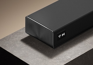 Vista en ángulo del LG Sound Suite H7 colocado sobre una mesa, mostrando su elegante cuerpo negro mate y su diseño de alta calidad.