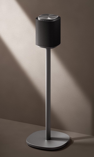 Vista completa de un altavoz inalámbrico Floor Standing con un soporte metálico que crea un sistema de cine en casa Dolby Atmos.