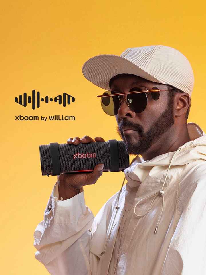 will.i.am, vestido de blanco, sostiene un xboom Grab.