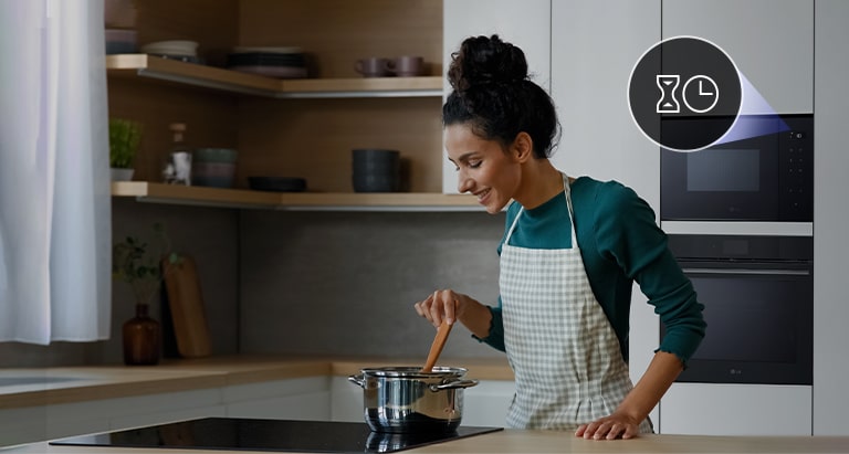 Une femme qui cuisine confortablement avec le minuteur de son micro-ondes