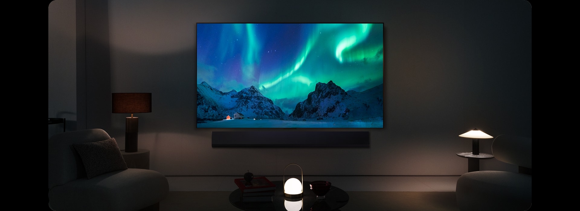Un TV LG OLED et une barre de son LG dans un espace de vie moderne de nuit. L’image à l’écran d’une aurore boréale est affichée, avec des niveaux de luminosité idéals. 
