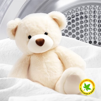 Image d'une couverture et d'un ours en peluche à l'intérieur d'un sèche-linge LG avec le logo de la British Allergy Foundation affiché.