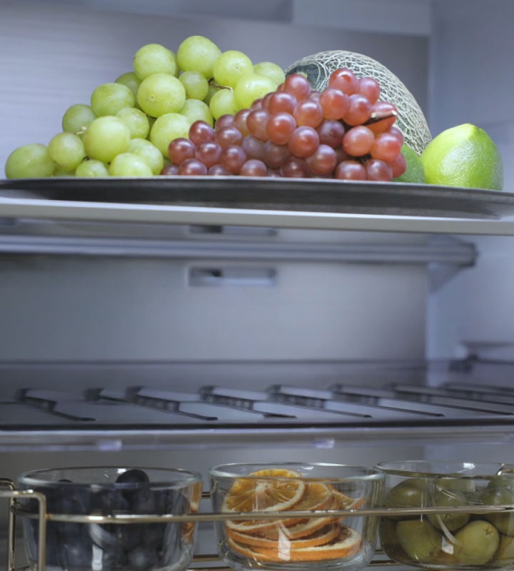 Vue intérieure du réfrigérateur congélateur LG (GBBW726AEV) avec des fruits sur l’étagère supérieure, des bouteilles de vin au milieu et plus de fruits sur l’étagère inférieure