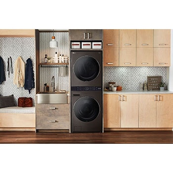 La LG WashTower® F761TOWERB2 en acier noir, installée dans une buanderie moderne avec des armoires en bois.