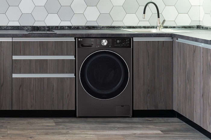 Le lave-linge LG F34R92BSTA de 13 kg en Platinum Black, soigneusement installé sous un comptoir dans une cuisine moderne.