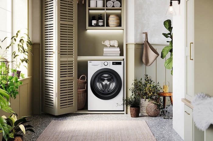 Lave-linge 9/6 kg LG F964R35WR blanc installé dans une buanderie confortable avec des placards à persiennes.