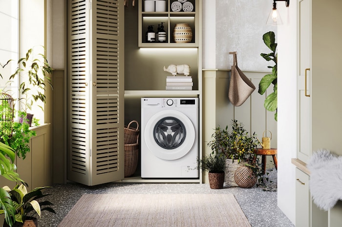 Lave-linge 9/6 kg LG F964R33WRS blanc installé dans une buanderie confortable avec des placards à persiennes.