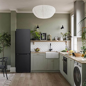 Réfrigérateur-congélateur LG GBV3100EEP noir mat, intégré dans une cuisine moderne aux tons verts, mettant en valeur son design élégant à porte plate.
