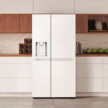 Réfrigérateur Américain LG GSLC40SWPE Blanc avec distributeur d'eau et de glace, intégré élégamment dans une cuisine moderne et lumineuse aux armoires blanches et en bois.