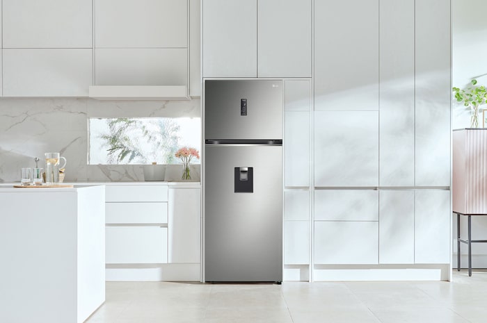Réfrigérateur Top-Freezer LG GTFV44PYBKD Argent Premium avec distributeur d'eau externe, intégré dans une cuisine blanche moderne.