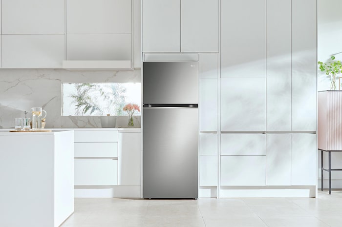 Réfrigérateur Top-Freezer LG GTBV36PZGKD Argent Premium, intégré avec élégance dans une cuisine moderne et minimaliste entièrement blanche.