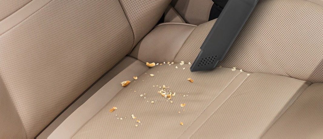 Cette image vous montre comment nettoyer le siège auto avec un suceur plat.