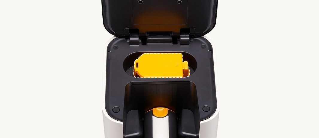 Il montre la batterie de l'aspirateur.