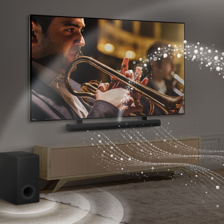 Une LG Soundbar, une LG TV et un caisson de basse sont placés dans un appartement urbain moderne. La LG Soundbar émet des ondes sonores composées de gouttelettes blanches emplissant la pièce et un caisson de basse crée un effet sonore à partir du bas. Ensemble, ils créent un effet de dôme dans la pièce.