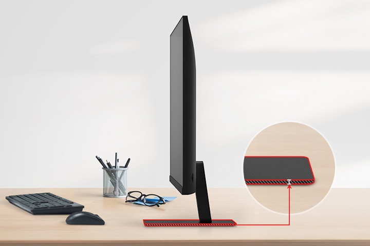 Un moniteur QHD avec un support ultra-fin est posé sur le bureau, avec un porte-crayon, des lunettes, un clavier et une souris à côté.