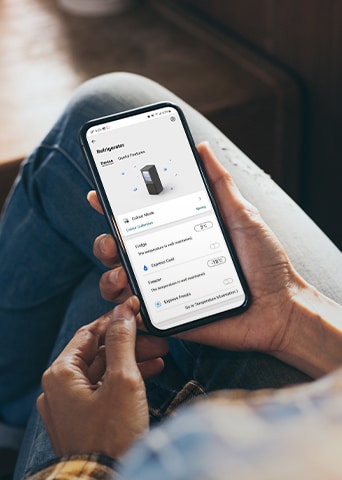 Image montrant une application qui vous permet de manipuler le réfrigérateur depuis le téléphone dans la main.