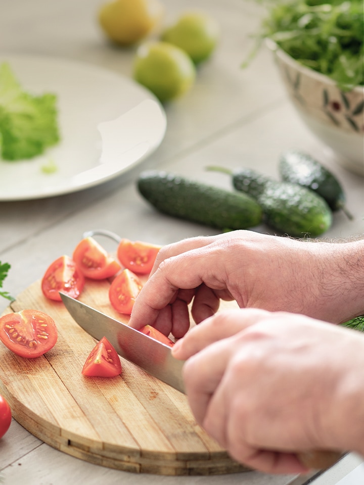 Image d’une découpe de tomates et d’une planche à découper avec un couteau.