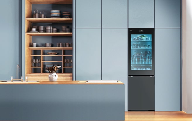 Une image d’un réfrigérateur placé dans une cuisine de couleur bleue.