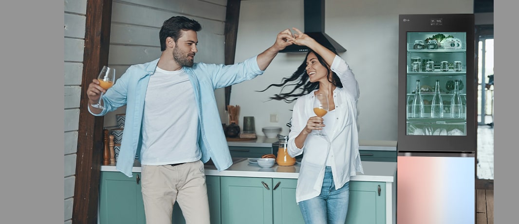 L’image d’un couple dansant face à un réfrigérateur aux couleurs rayonnantes.