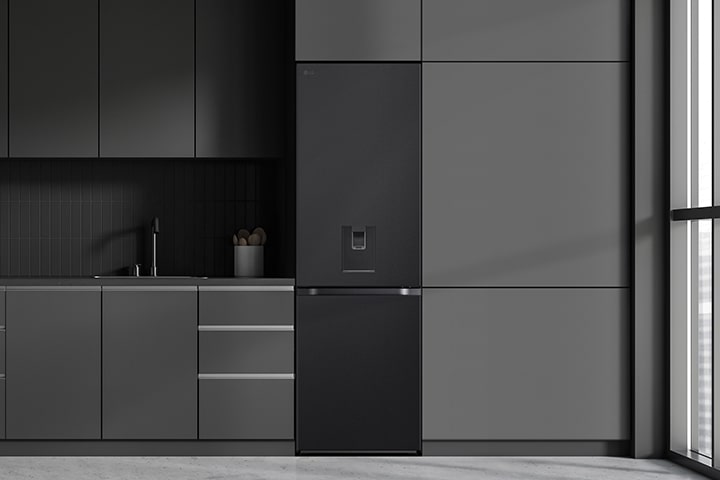 Cuisine moderne avec réfrigérateur LG noir à droite, armoires grises et fenêtre à l'extrême droite.