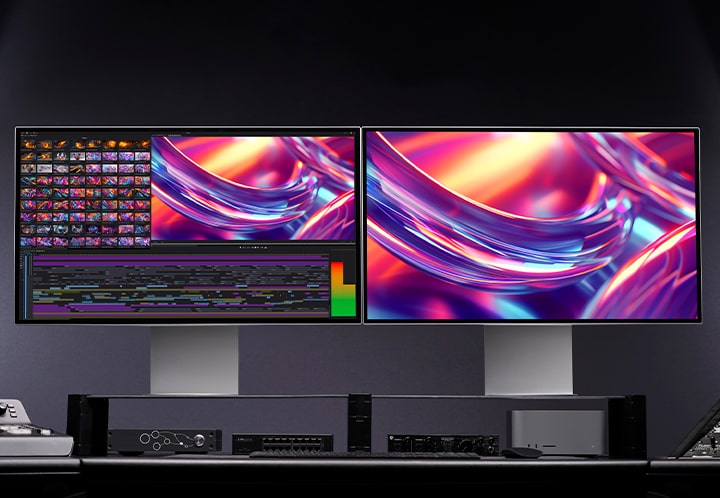 2 moniteurs UltraFine identiques avec des images sont placés dans un studio sombre.