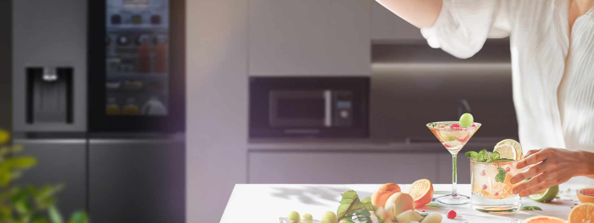 Une femme prépare un Boissons sans alcool bien décoré dans la cuisine avec des ingrédients éparpillés sur la table.