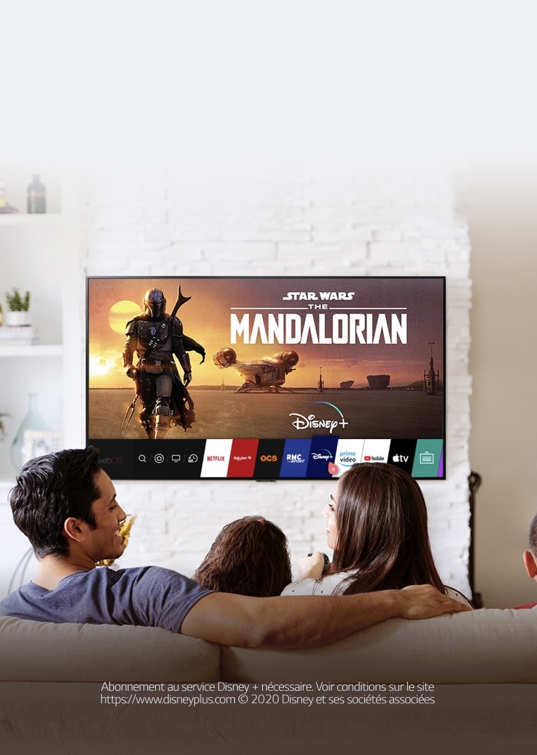 Une famille sur son canapé qui regarde Disney+ sur un téléviseur LG. Abonnement au service Disney + nécessaire. Voir conditions sur le site https://www.disneyplus.com © 2020 Disney et ses sociétés associées