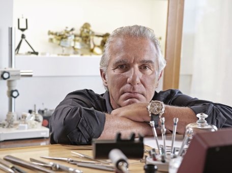 Antoine Preziuso is looking at his watch in his workspace