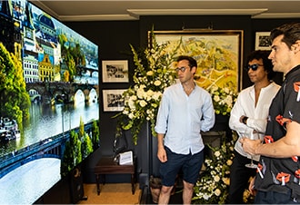 Three male attendees of SIGNATURE’s Goodwood event take a closer look at the clear, vivid imagery provided by the LG SIGNATURE 77-inch OLED TV.