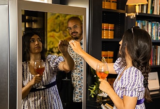 Two attendees to the LG SIGNATURE Goodwood races event check out the LG SIGNATURE Wine Cellar while testing its InstaView feature by knocking on its glass panel.