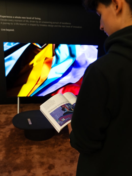 A visitor of the exhibition is shown reading the Monocle magazine at the LG SIGNATURE exhibition.