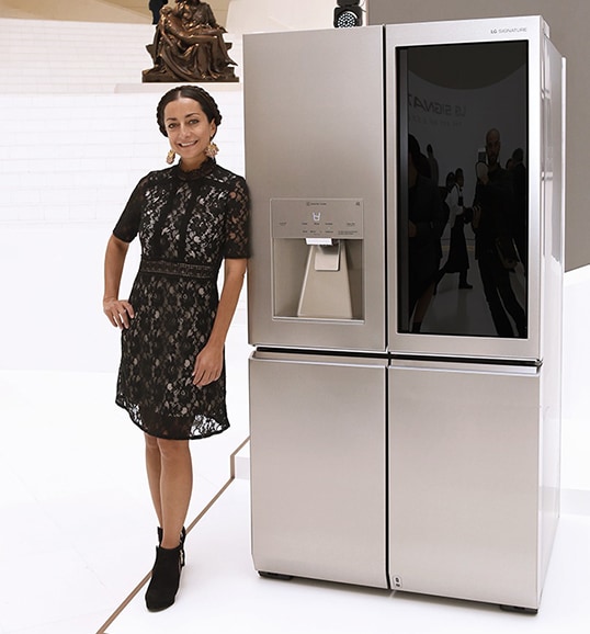 an woman is standing in front of lg signature refrigerator at lanching event in mexico