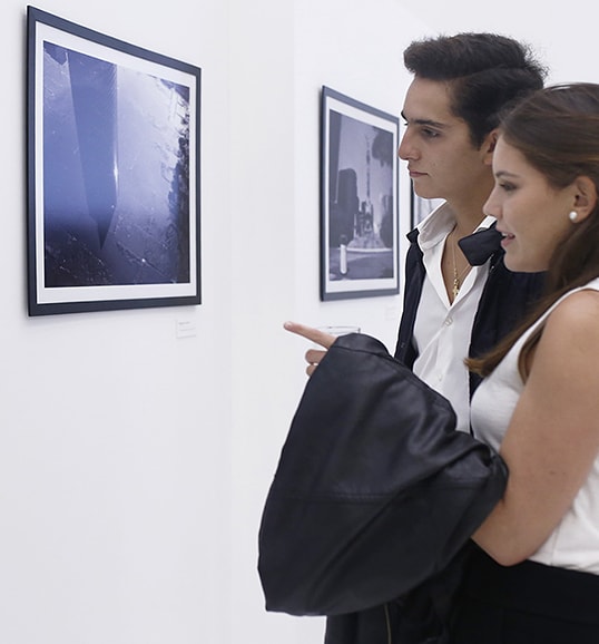 two people are standing in front of lg signature commercial photographs at lanching event in mexico