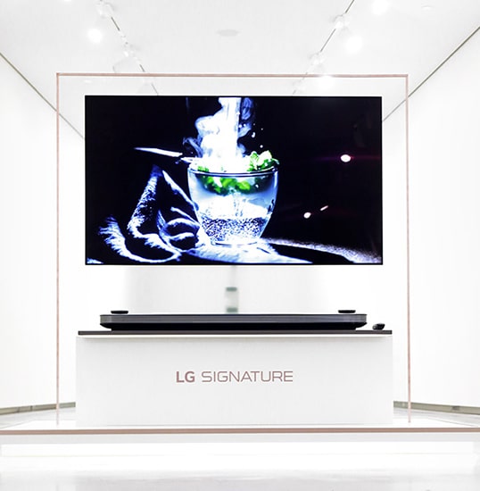 lg signature oled tv is hung on the glass wall displayed on the right middle of the lg signature launching event in nordics