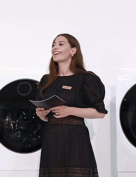 main mc woman influencer is talking on the main stage in front of lg signature washing machine displayed at launching event in nordics