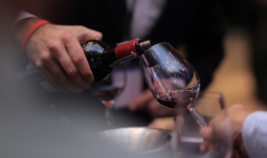 James Suckling is pouring wine into the wine glass.