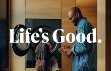 Pai e filha compartilhando um momento feliz ao lado de uma LG WashTower AI aberta, com o texto "Life's Good." sobreposto.