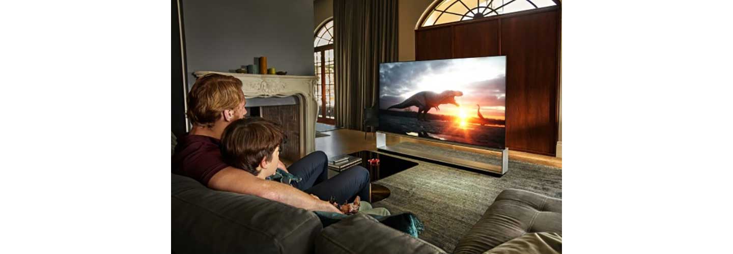 A father and son watch a movie on LG’s OLED TV which provides a true cinematic experience