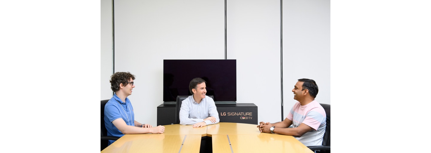 Carlos Olave, LG Global HR Leader, having a conversation with LG employees in the office. 