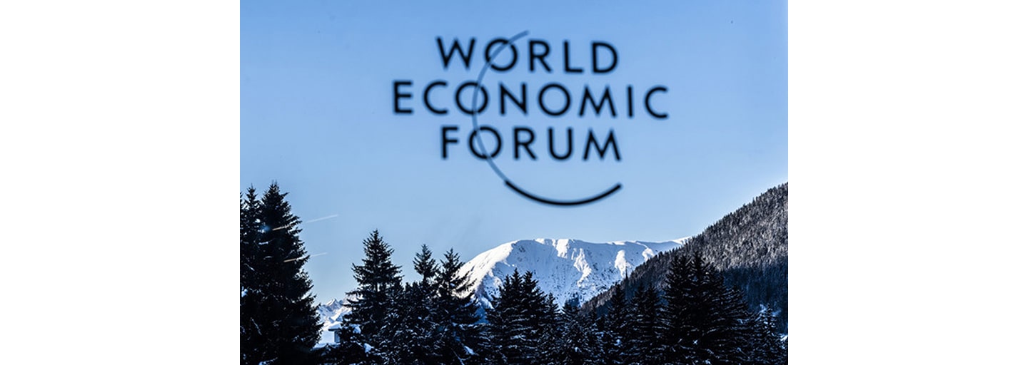 The logo of WEF with a view of Davos, Switzerland in the background.