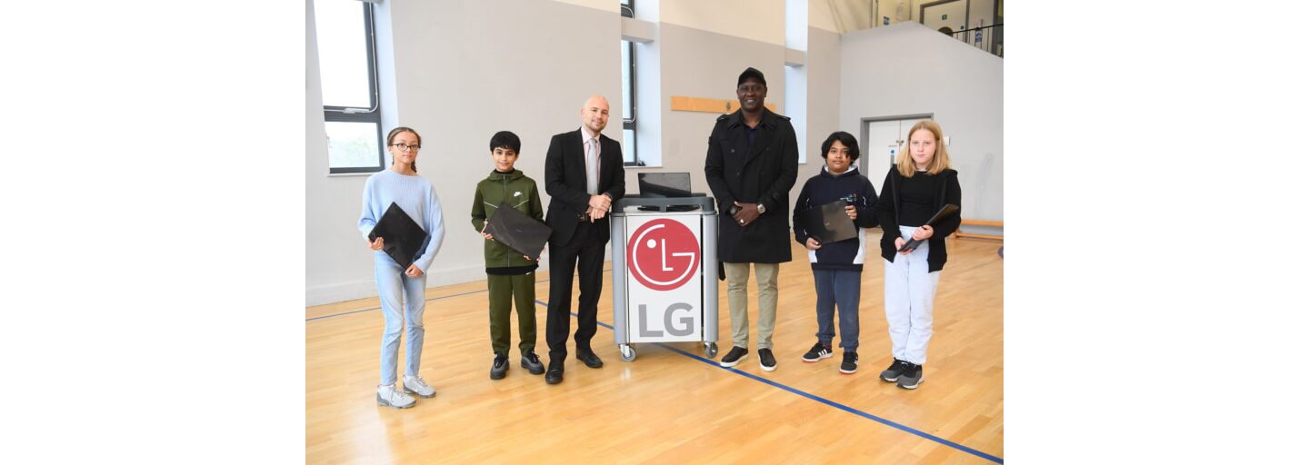 English football legend Emile Heskey posing with children taking part in the LG Laptop Library program.