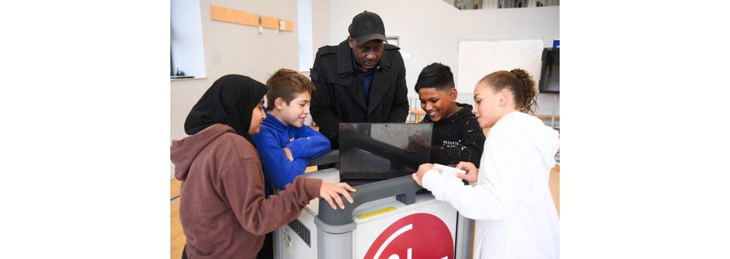 Students taking a closer look at LG gram with former English professional football player Emile Heskey.