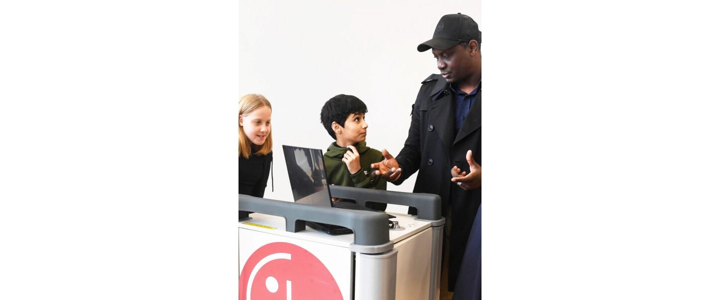 English football legend Emile Heskey talking to a student benefitting from the LG Laptop Libraries program.