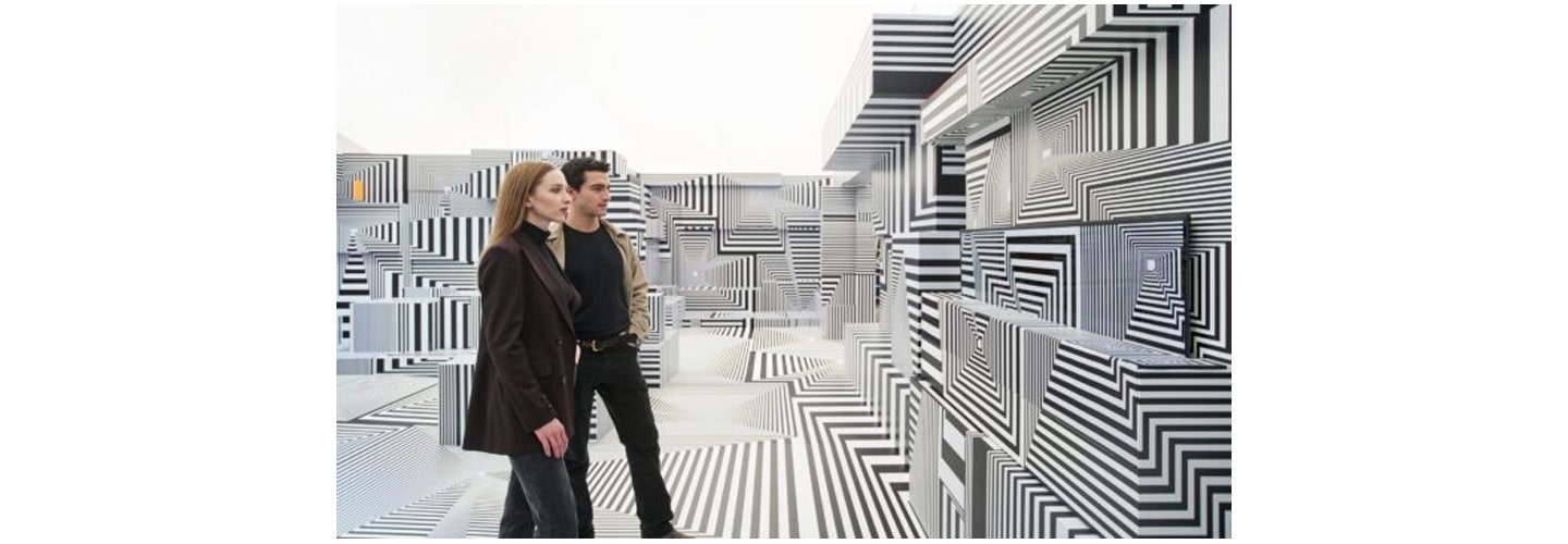 Two visitors taking a closer look at LG OLED-powered “Into the Maze” installation by the German artist, Tobias Rehberger