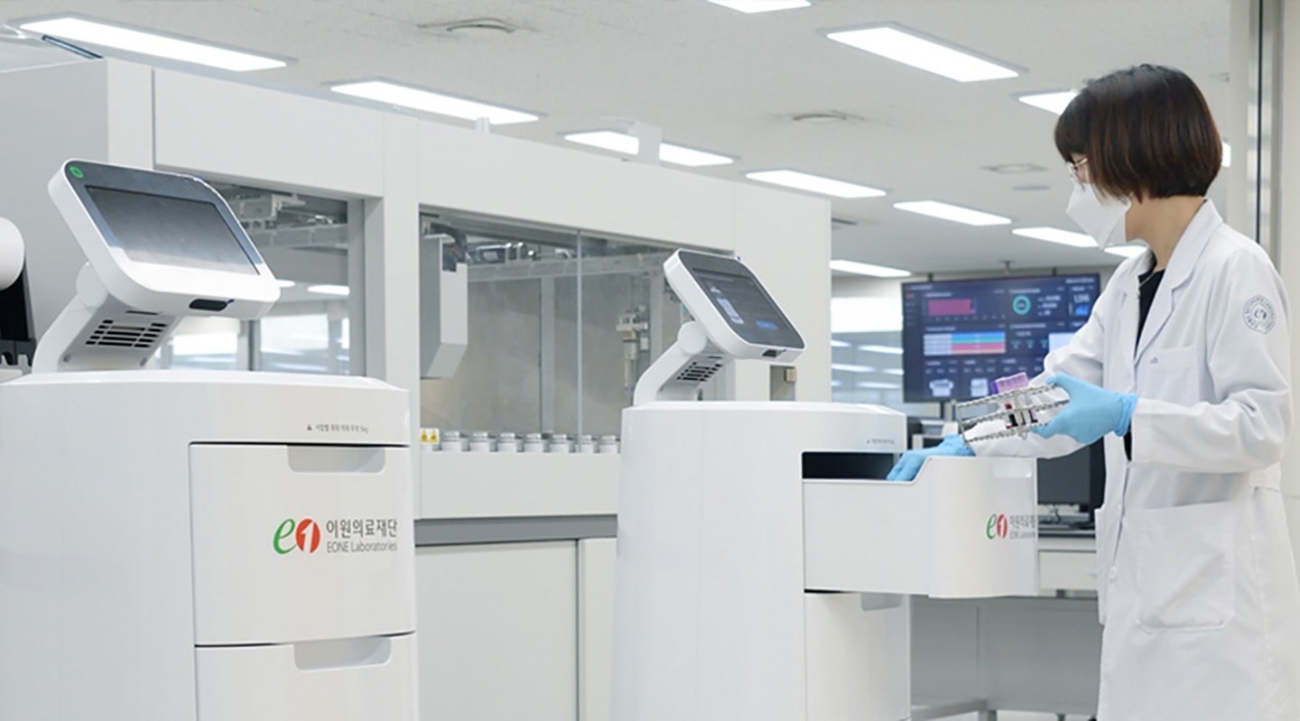 A scientist working with the help of LG CLOi ServeBot in the lab.