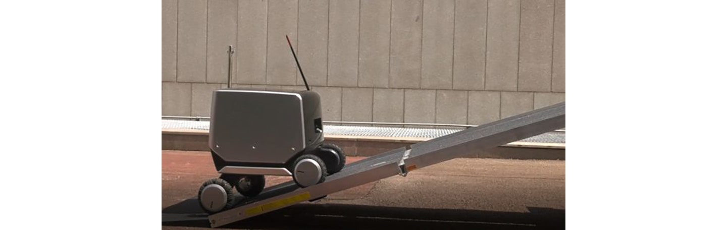 LG’s four-wheeled indoor-outdoor delivery robot moving up a steep ramp.