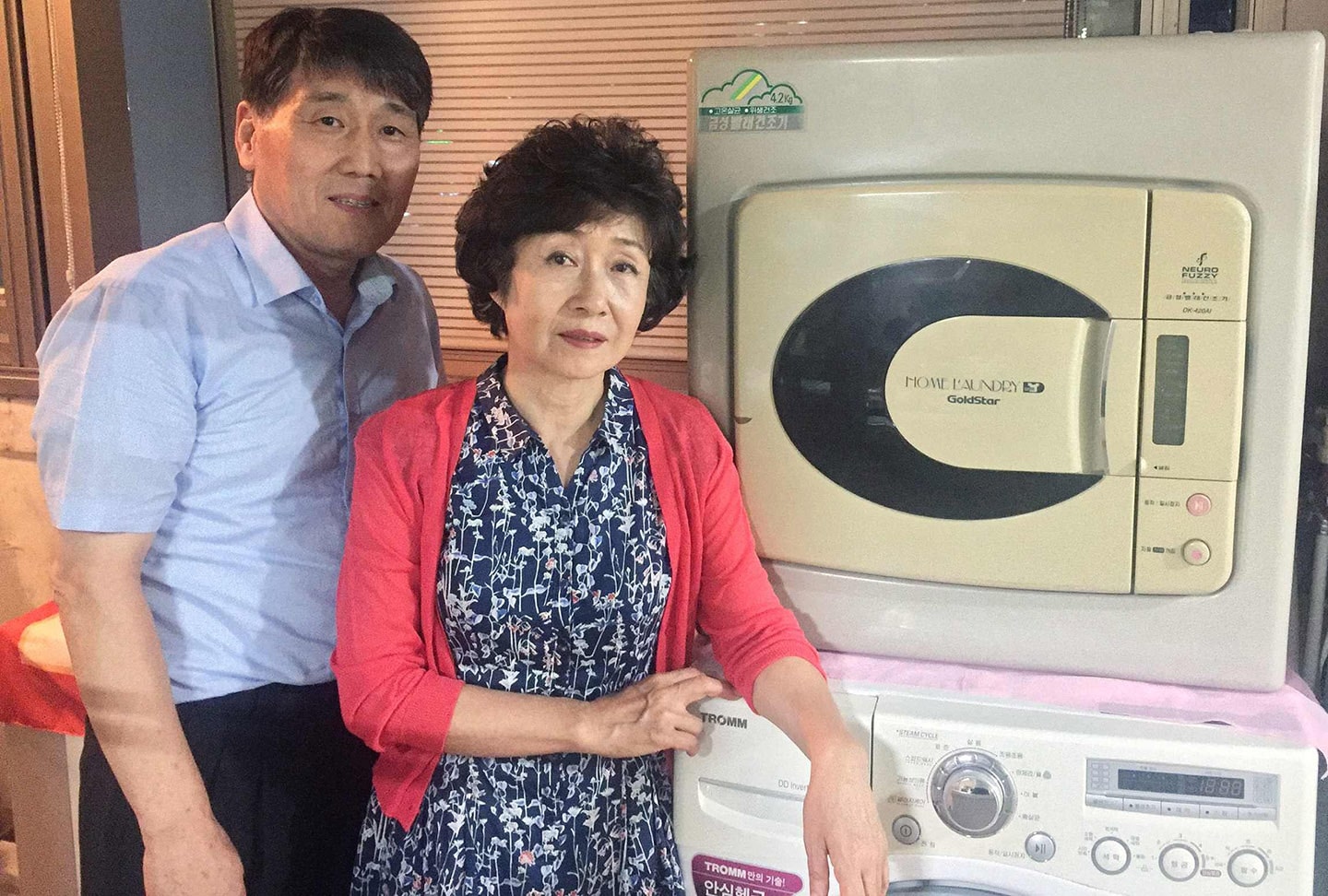 The owners of a 20-year-old Goldstar dryer posing with their old machine